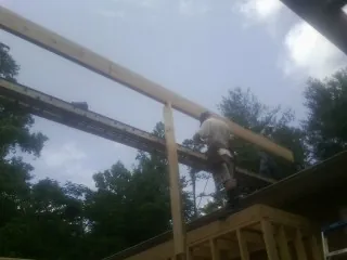 Carpenter setting a ridge beam over a new addition frame — Ice Dam Removal by Roofing Brothers in Coon Rapids