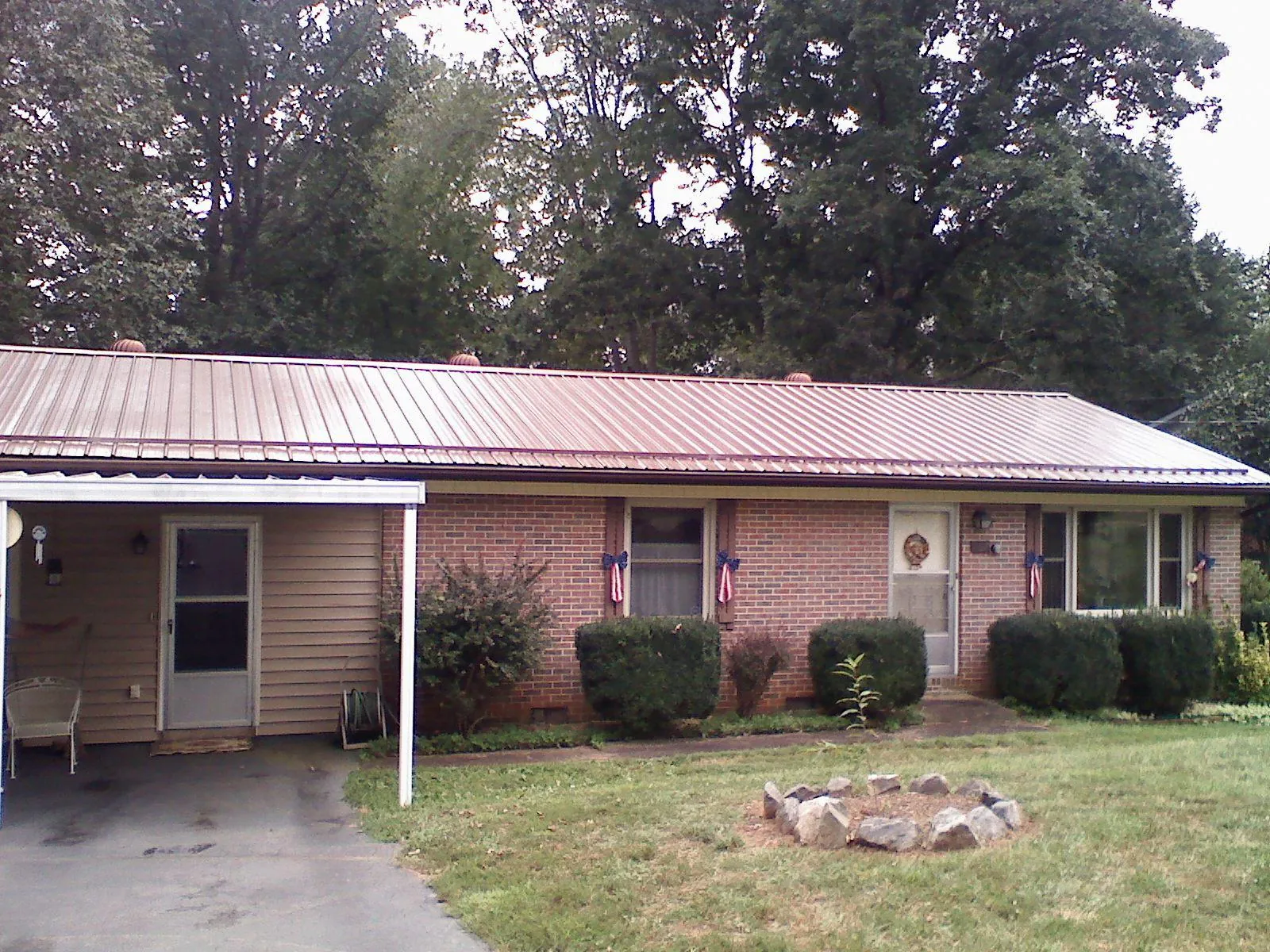Bronze metal roof and carport on a brick ranch home — Roof Repair work by our crew in Coon Rapids